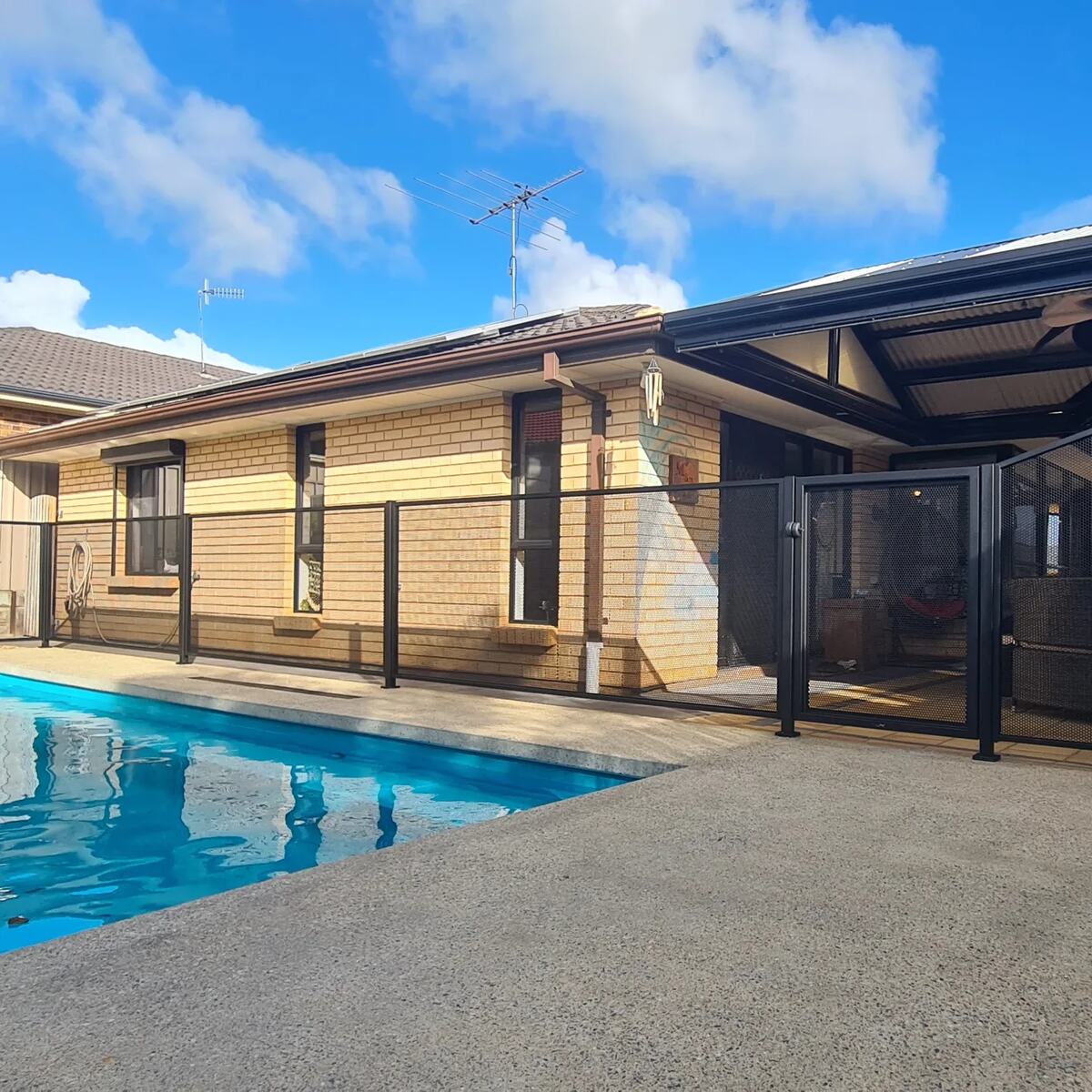 Pure Perf pool fencing in Textured Black beside a blue pool and verandah, SA